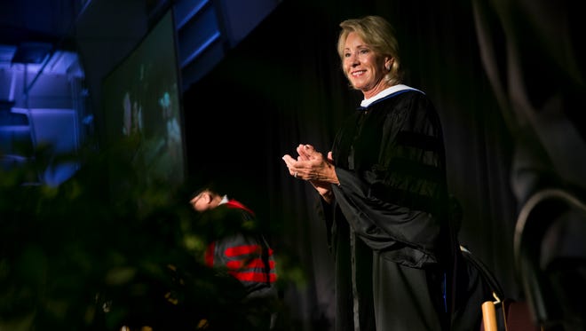 U.S. Secretary of Education Betsy DeVos greets Ave Maria University graduates as they walk across the stage to receive their diplomas at Golisano Field House Saturday, May 5, 2018 in Ave Maria. DeVos gave the commencement address during the ceremony.