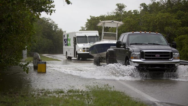 Vehicles drive through a flooded Goodland Drive on June 6, 2016. (Erica Brechtelsbauer/Staff)