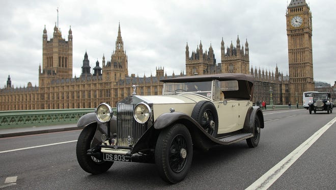 Vintage Rolls Royce cars drive past the Houses of Parliament during a centenary parade on Feb. 6, 2011 in London. Rolls Royce is celebrating the 100th anniversary of the introduction of the 'Spirit of Ecstasy' or 'Flying Lady' icon that is found on the front of their cars.
