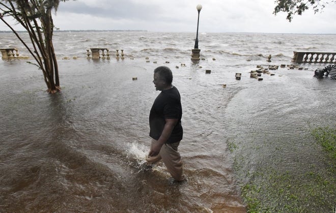 Alfred Lester walks through the standing water near the seawall in Memorial Park as residents of NE Florida were feeling the effects of Hurricane Idalia Wednesday morning, August 30, 2023. A large number of the balustrades along the seawall in the park have been damaged by the storm-fueled waves.