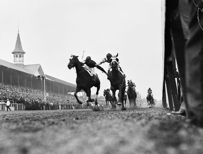 This 1933 photograph, showing the furious stretch battle between jockeys Don Meade on Brokers Tip (right) and Herb Fisher on Head Play, at the finish of the 1933 Kentucky Derby, was almost an accident. Courier-Journal photographer Wallace Lowery lay on the ground, stuck his camera under the rail and shot. This picture is the result. It is probably the most widely circulated picture in the history of the Derby.