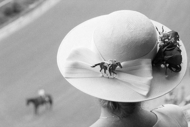 A woman looks down on the track at Churchill Downs from Millionaires Row. By Alan Lessig, The Courier-Journal. May 7, 1992.
