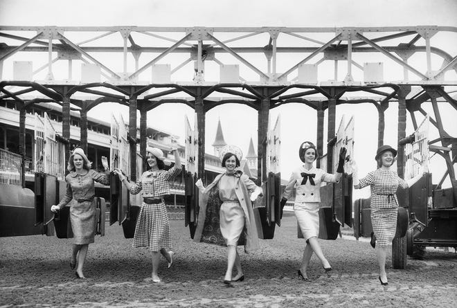 Fashion models pose the starting gate at Churchill Downs, wearing the latest styles for the upcoming Kentucky Derby in 1965.