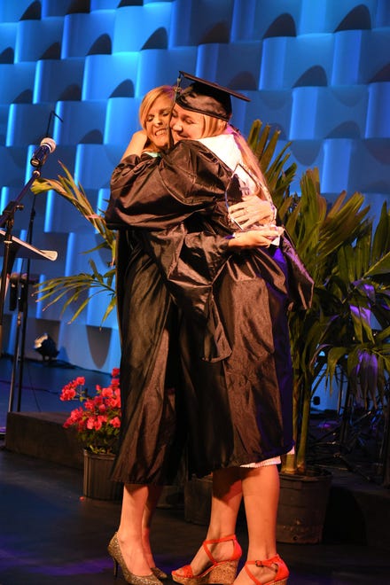 Morgan Jones receives the Principal's Award and a hug from Melissa Scott, left. Marco Island Academy held its 2019 commencement ceremony Friday evening at the Family Church.