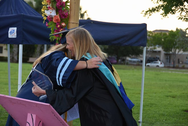 MIA Principal Melissa Scott gives the Principal's Award and an hug to graduate Lauren Faremouth. Marco Island Academy, Marco Island's charter high school, held a "drive-in" graduation ceremony for their 47 graduating seniors Friday evening in the parking lot at Veterans' Community Park.