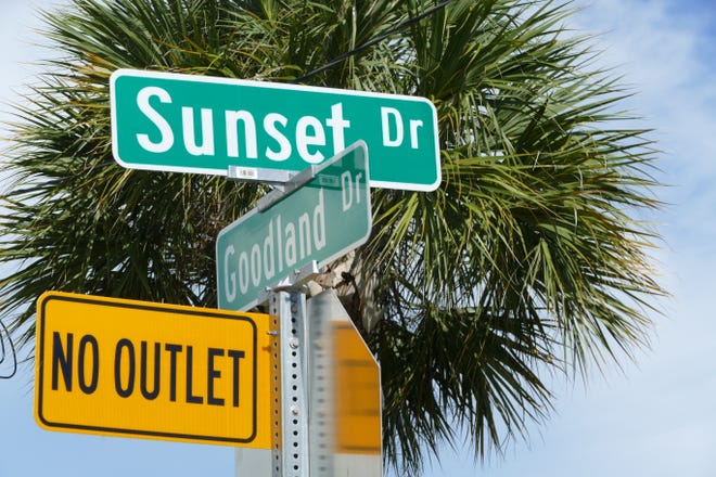 Sunset Drive and Goodland Drive signs stand in front of a palm tree on June 22, 2020.