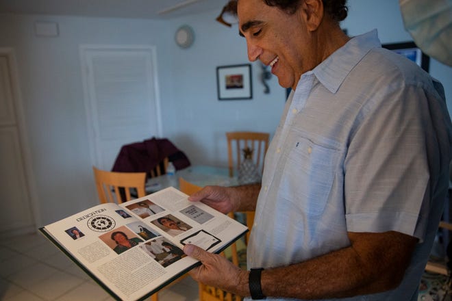 George Abounader looks through his Class of 1999 St. John Neumann Catholic High School yearbook, Friday, July 17, 2020, at his home in Marco Island.   Abounader recently retired in June after spending 47 years as an educator with 21 years spent as the principal of Marco Island Charter Middle School.