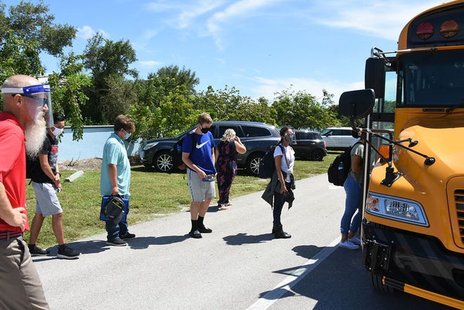 HIstory teacher Randy Montgomery gets students onto the school bus after classes Tuesday. Marco Island Academy, the island's charter high school, opened its doors to students on Wednesday, August 12.