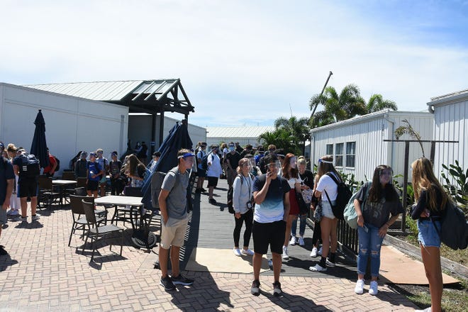 Students wait for their rides after classes on Tuesday. Marco Island Academy, the island's charter high school, opened its doors to students on Wednesday, August 12.