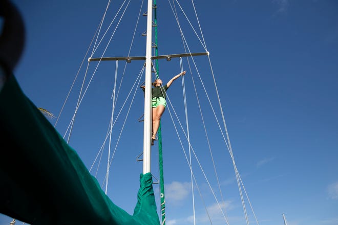Nathalie Meyers climbs the main mast of her ship, The Far Side, Thursday, Dec. 24, 2020, at their home in Marco Island.