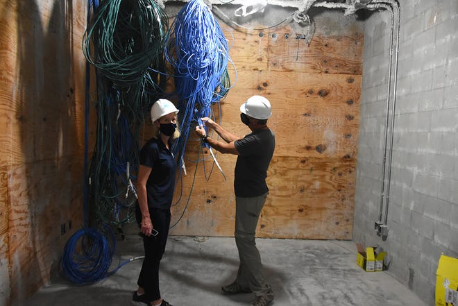 Marco Island Academy founder and board chair Jane Watt and Mark Melvin of the school's leadership advisory board with some of the  high-tech wiring, part of the construction at the new campus on San Marco Blvd. The school is on track to have the gymnasium ready for graduation in May, and the new academic building for the next school year in August.