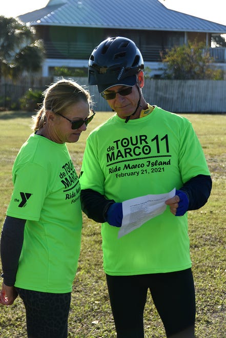 Lisa and John Hamilton consult the route map before heading out. The 11th Tour de Marco saw hundreds of cyclists riding 15 or 30 miles around the island on Sunday morning to benefit the YMCA.