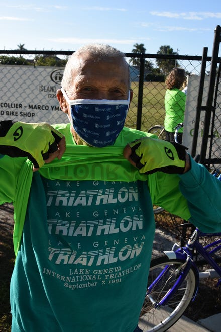 YMCA board member Chuck Thomas, 87, uncovers his second shirt, marking him a triathlete. The 11th Tour de Marco saw hundreds of cyclists riding 15 or 30 miles around the island on Sunday morning to benefit the YMCA.