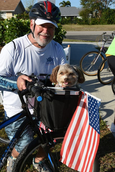 MIchael Passero prepares to ride with Luke, his Havanese. The 11th Tour de Marco saw hundreds of cyclists riding 15 or 30 miles around the island on Sunday morning to benefit the YMCA.