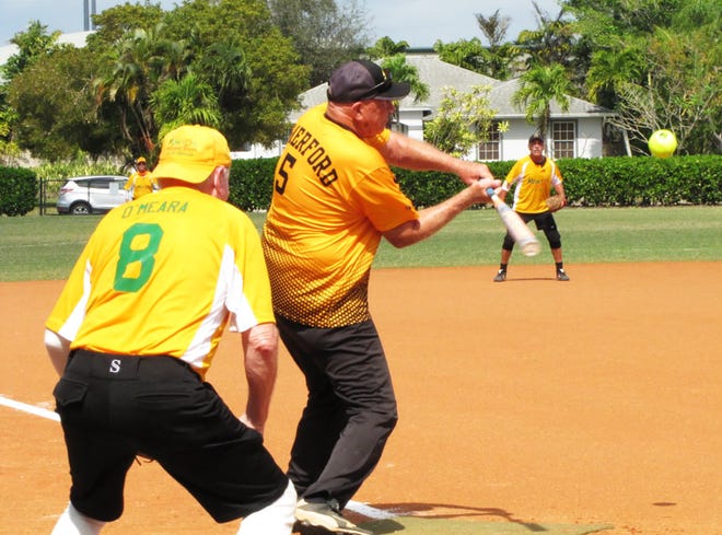 Sand Bar's Pat Comerford drives the ball to the opposite field for one of his two hits against Mango's.