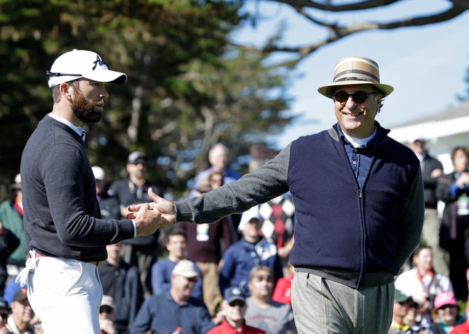 Actors Lucas Black, left, and Andy Garcia, right, greet each other after a putt on the third green of the Pebble Beach Golf Links during the celebrity shootout event of the AT&T Pebble Beach Pro-Am golf tournament on Wednesday, Feb. 5, 2014, in Pebble Beach, Calif. Black and Garcia won the event. (AP Photo/Eric Risberg)
