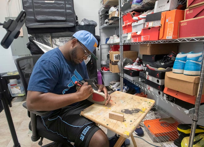 Al Harris works on cleaning and restoring a pair of vintage athletic shoes at Pressure Footwear and Apparel on Tuesday, March 22, 2022. Pressure is hosting a Sneaker Party at Washington High School on April 3. The gathering will bring sneakerheads together to buy, sell, trade vintage shoes or get the latest footwear styles.